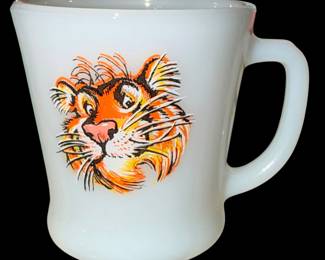 This vintage Anchor Hocking Fire-King milk glass mug features the iconic promotional tiger graphic from the 1960s Esso gas station "Put a Tiger in Your Tank" campaign.