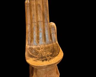 This is a hand-carved solid wood hand chair featuring an upright palm and fingers that form a sculptural backrest.