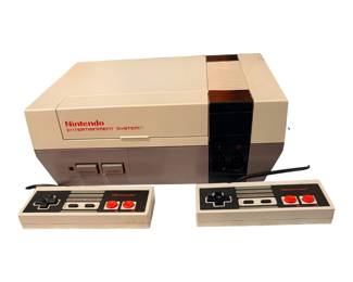an original Nintendo Entertainment System (NES-001) front-loading home video game console paired with two standard wired controllers