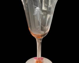 a vintage pink depression glass wine goblet featuring an etched floral or leaf design