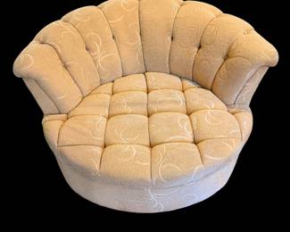 vintage, channel-tufted round swivel armchair upholstered in a pale yellow textured fabric with a subtle swirl pattern.