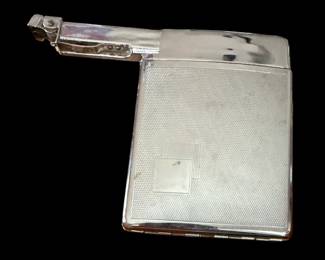 It is a petrol/fluid-based lighter system, not a butane lighter. When the spring-loaded enclosure is pressed open to retrieve a non-filtered cigarette, closing the case triggers the mechanical arm on top to spark and light automatically.