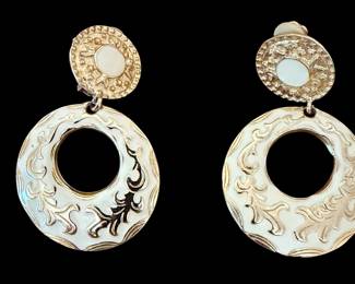 vintage gold-tone clip-on earrings feature textured circular tops with faux pearl or enamel cabochons and large dangling hoops with embossed floral and leaf enamel details