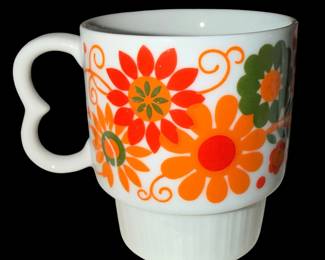 vintage stacking mug features a vibrant retro orange and green floral "flower power" design complete with a distinctive heart-shaped handle