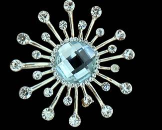 vintage silver-tone rhinestone starburst or "Sputnik" atomic-style brooch featuring a large pale blue or crystalline center stone