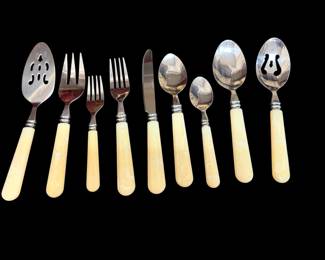 Cooks Club flatware with cream or ivory swirled resin handles features a classic, French-inspired design that closely mirrors traditional Laguiole cutlery. Produced primarily in the 1990s, these sets are known for their distinctively shaped handles, decorative bolster rings, and specialized serving items like the slotted straining spoons shown on either end. 34 piece pieces.