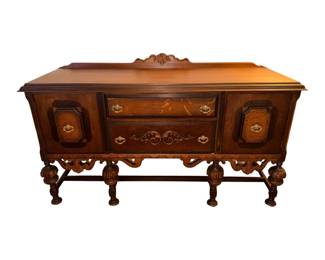 This is an antique early 20th-century Jacobean Revival style wooden sideboard or buffet featuring burled wood accents and ornate carved legs.