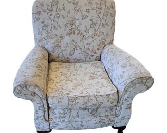 classic floral-patterned upholstered armchair with rolled arms and dark wood feet