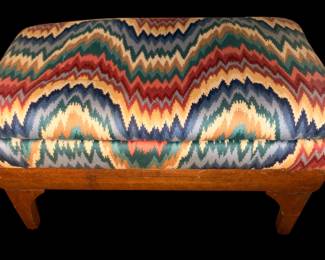 This is a vintage oak a vintage wooden footstool upholstered in a colorful, zigzag flamestitch pattern. 