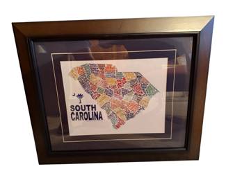 This framed wall art features a colorful typography map of South Carolina made up of city and town names.