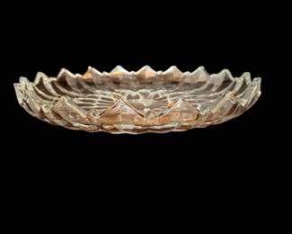 This is a vintage press, glass cake plate with saw tooth edges