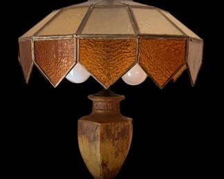 vintage Arts and Crafts or Mission-style table lamp with an amber slag glass geometric shade and a decorative butterfly finial