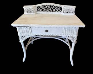 vintage white wicker writing desk and vanity featuring a single central drawer and two top corner cubbies.