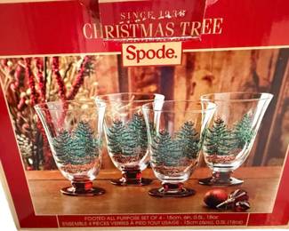 This is  a set of four Spode Christmas Tree Glass Footed All Purpose Glasses with red stems and an 18-ounce capacity.