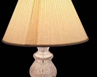 A pair of classic vintage cut-crystal table lamp with a brass or gold-tone base and a pleated beige fabric shade