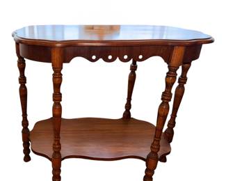 an antique wooden two-tier accent or parlor table featuring spool-turned or bobbin legs and a scalloped skirt on  top