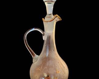 vintage clear glass decanter featuring a side handle, gold leaf floral accents, and a matching faceted glass stopper