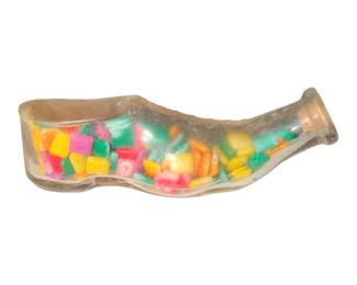 a vintage clear glass shoe or slipper novelty candy container filled with colorful small candies.
