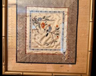 a vintage framed Chinese silk embroidery featuring a small bird and floral motifs on a cream-colored silk panel