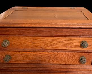 an antique oak tabletop clerk’s or sewing desk with a lift-top lid and dual drawers