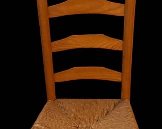 This classic wooden ladderback chair features a four-slat back and a hand-woven rush seat accented with traditional acorn finials.