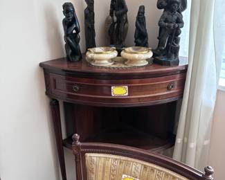 Corner shelving unit, alabaster bowls, wooden statues, side chair