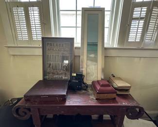 Period living space with plantation shutters, vintage Palace theater poster, rotary phone, and antique furnishings