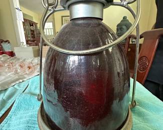 Antique railroad-style lantern with red amber glass globe and metal handle