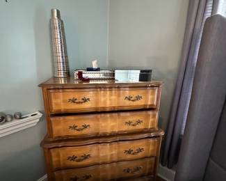 Vintage wooden chest of drawers with brass hardware and decorative accents