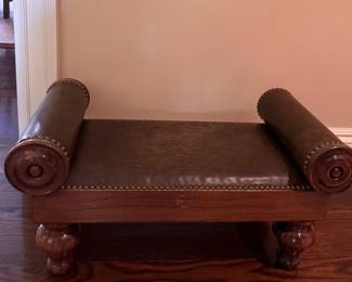 Leather footstool with nail head trim.