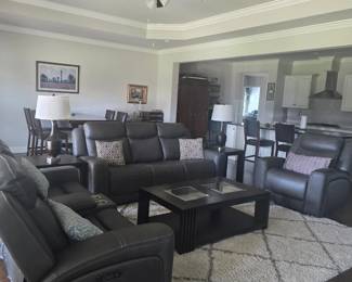 Complete set of electric reclining grey leather sofa, console loveseat, chair and coffee table, matching endtables, lamps and area rug 