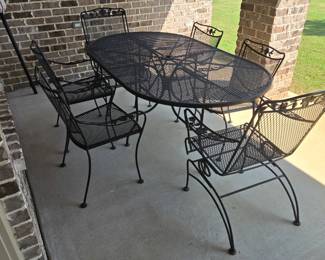 Large oval wrought iron patio set with 6 chairs and beige umbrella