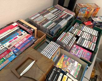 Collection of vintage media including 8-track & cassette tapes, CDs, cassette tapes, VHS movies