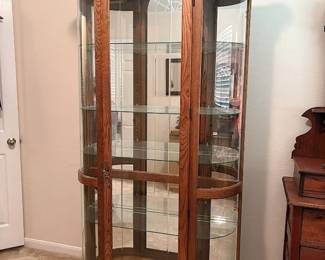Vintage oak curio cabinet with curved glass sides and interior lighting