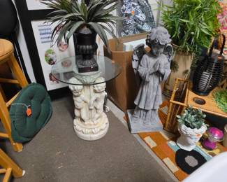 Round pedestal table with glass top, Urn with greenery, Angel Statue