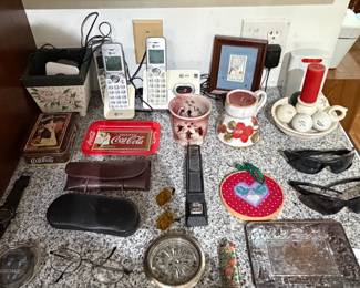 Counter lot with Coca-Cola tray, brass compass, cordless phone, ashtrays and framed photos