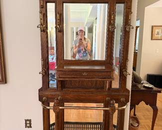 Antique oak hall tree with beveled mirror, brass hooks and umbrella stand