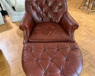 Tufted brown leather club chair with matching round ottoman
