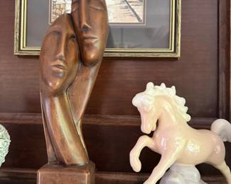 Carved wood sculpture of three faces and porcelain rearing horse figurine