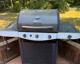 Propane gas grill with side shelves on deck