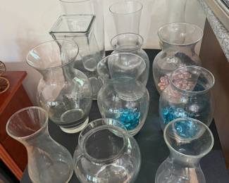 Collection of clear glass vases, hurricane cylinders and bowls with decorative filler