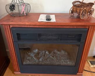 Electric fireplace heater in wood mantel cabinet with wicker cart basket