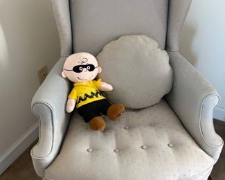 Cream tufted wingback armchair with Charlie Brown Peanuts plush doll