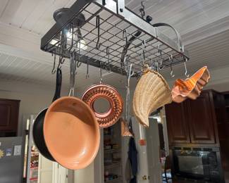 Hanging pot rack with copper cookware, bundt mold and woven baskets