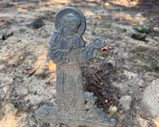 Concrete garden statue of a robed saint figure with halo