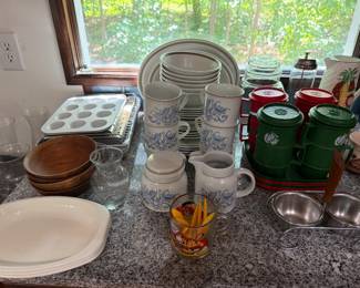 Blue and white stoneware dinnerware and steins, muffin tin, wood bowls, green canisters and stainless mixing bowls