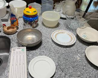 Kitchen counter with ceramic cookie jar, silver bowl, china plates and glass pitcher