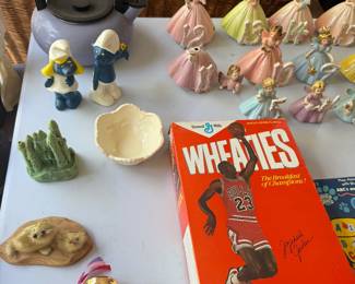 Smurf figurines, pastel ceramic bell figurines, gold theater masks and Michael Jordan Wheaties box