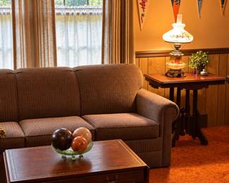 Sleeper sofa , antique coffee table, vintage felt sports pennants