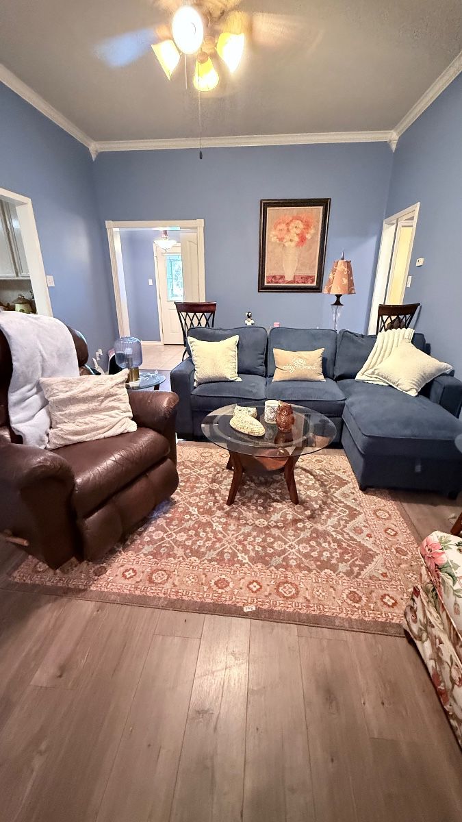 Living Room Furniture – Sectional sofa, leather recliner, glass-top coffee table, area rug, floor lamp, framed wall art, and accent décor. Items sold individually unless noted.